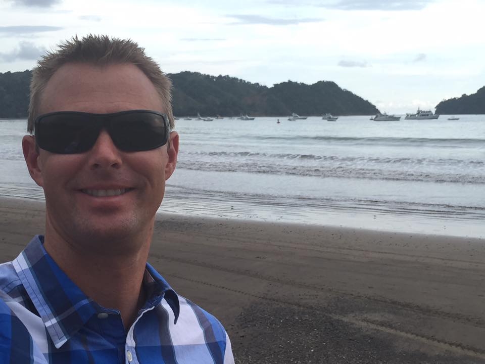Dr. Caudill at the beach and taking a photo selfie