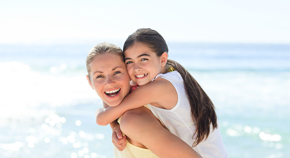 Child on woman's back at beach, Caudill ...... , Emergency Orthodontist