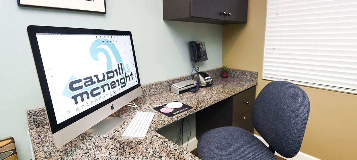 Caudill & McNeight Orthodontics office, New Year, New Website, office chair and computer screen with logo
