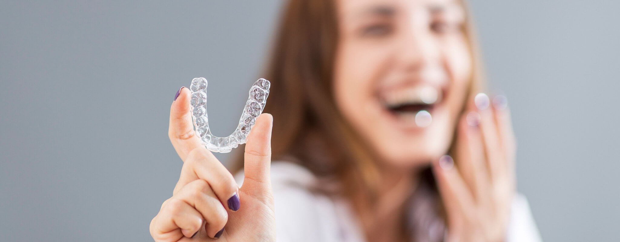 adult shows off her invisalign tray on her first day with Invisalign