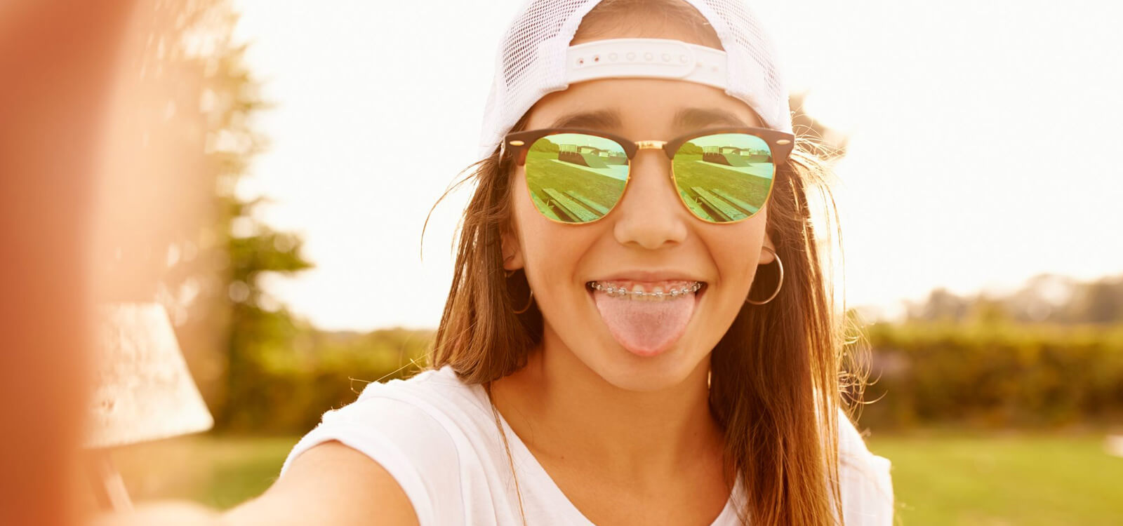 teen sticks out her tongue after cleaning it with a tongue scraper