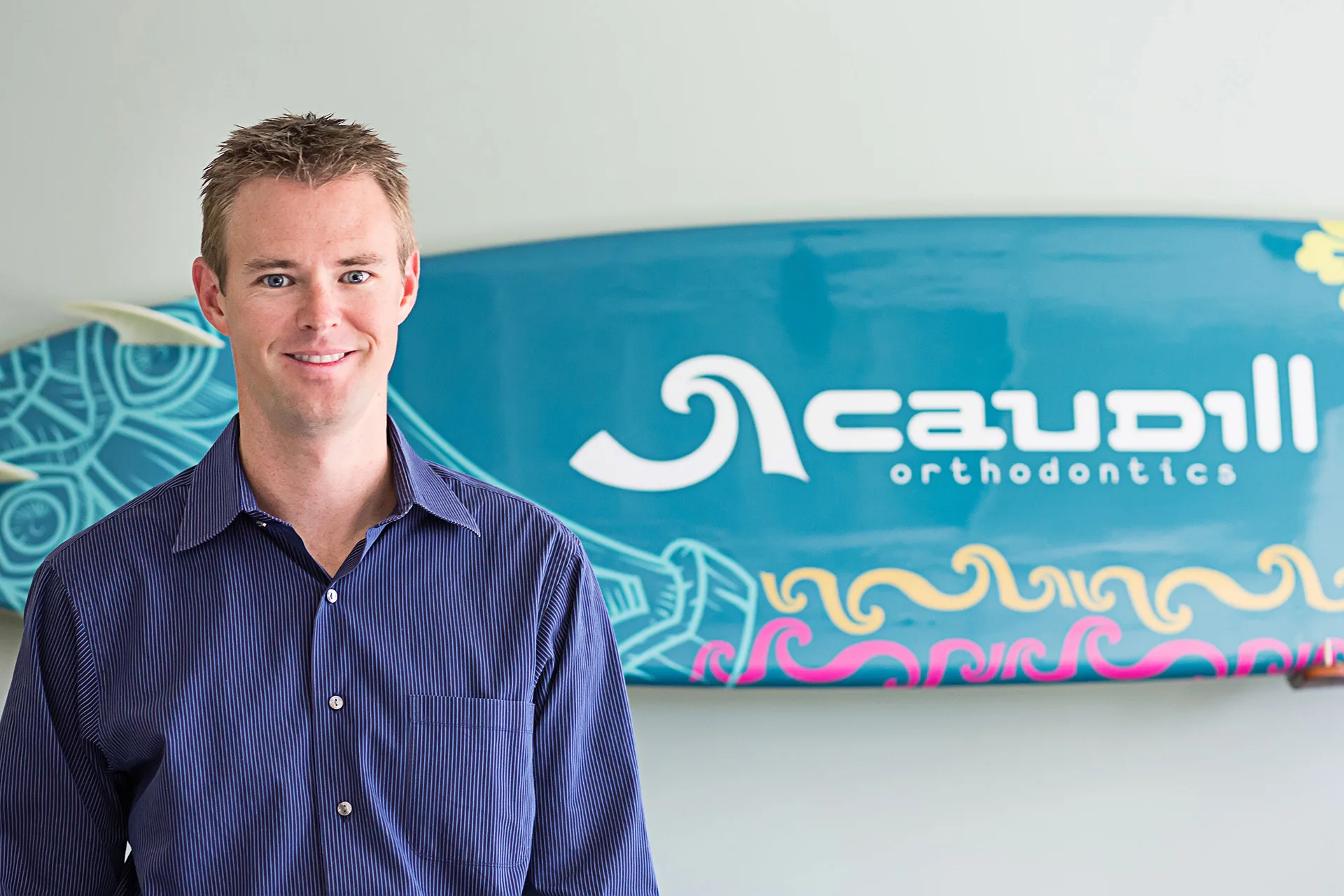 Dr. Ryan smiling with Caudill ortho surfboard