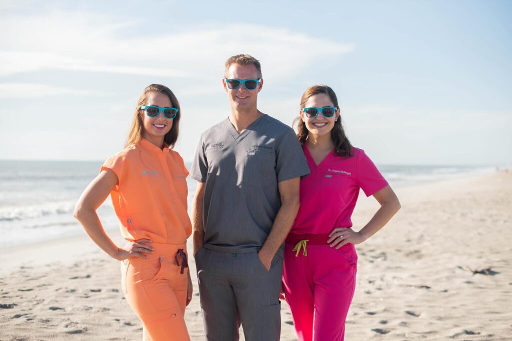 Dr. Naglieri, Dr. Caudill and Dr. McNeight standing on beach, wearing summer sunglasses, Merritt Island, Viera and Melbourne orthodontist